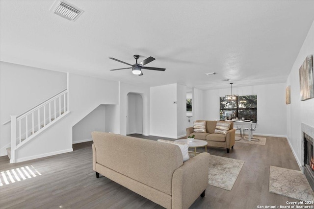 living room with ceiling fan with notable chandelier and hardwood / wood-style flooring