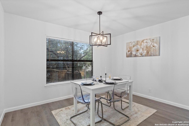 dining space with dark hardwood / wood-style flooring and an inviting chandelier