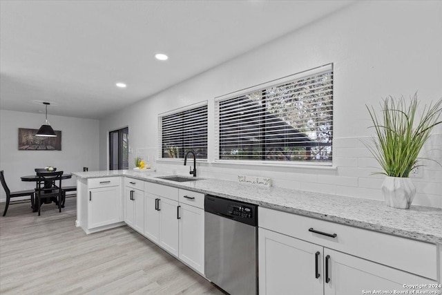 kitchen featuring pendant lighting, dishwasher, sink, light hardwood / wood-style flooring, and white cabinetry