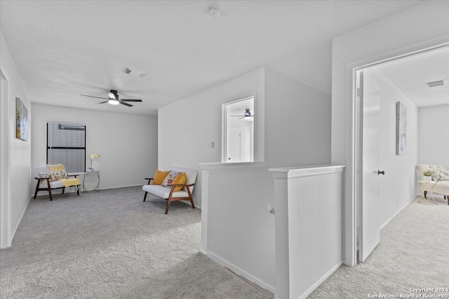 sitting room featuring light colored carpet and ceiling fan