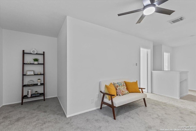 living area with ceiling fan and light colored carpet