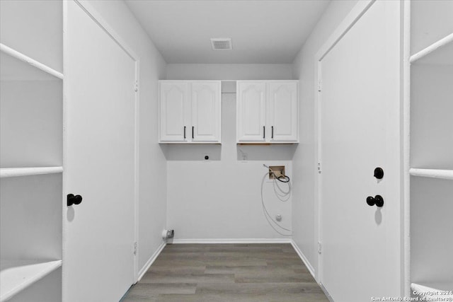 washroom featuring hookup for an electric dryer, light hardwood / wood-style floors, cabinets, and hookup for a washing machine