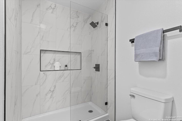 bathroom featuring tiled shower and toilet