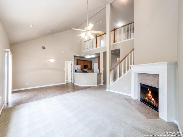 unfurnished living room with light carpet, a fireplace, high vaulted ceiling, and ceiling fan