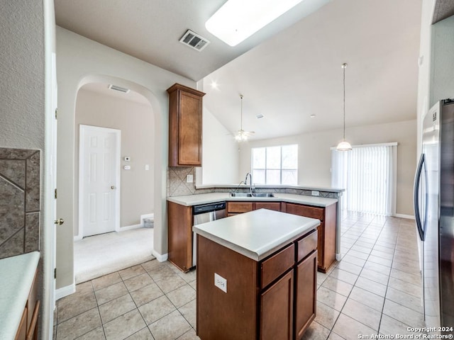 kitchen featuring sink, ceiling fan, appliances with stainless steel finishes, a kitchen island, and kitchen peninsula