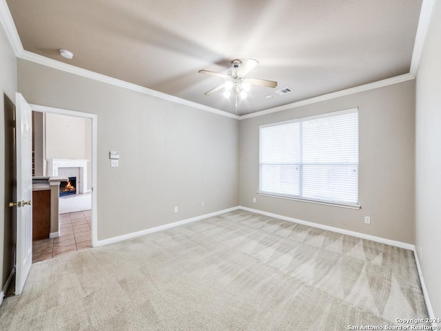 empty room with ceiling fan, ornamental molding, and light carpet