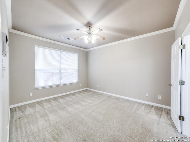 unfurnished room with ceiling fan, light colored carpet, and ornamental molding