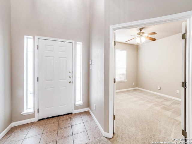 carpeted entryway with ceiling fan and a healthy amount of sunlight