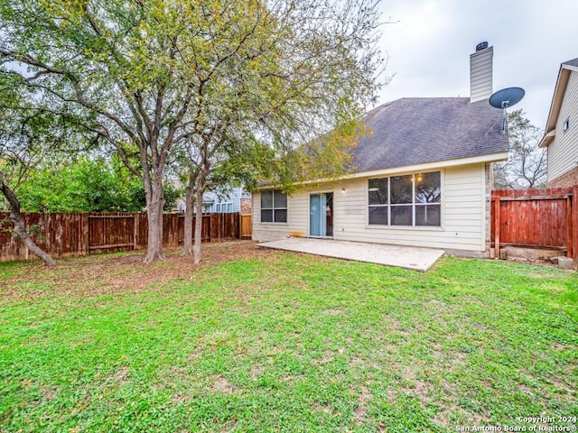 back of house with a lawn and a patio