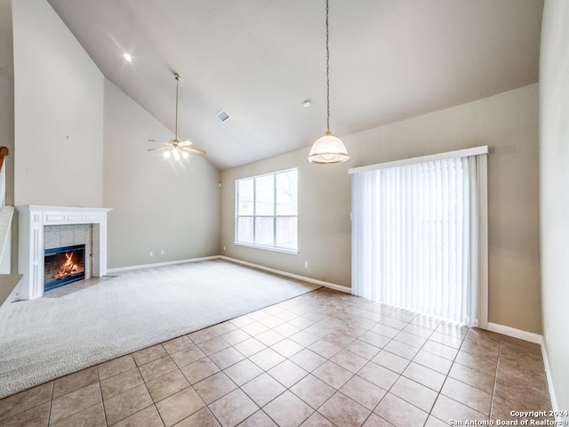 unfurnished living room with a tiled fireplace, ceiling fan, light tile patterned floors, and high vaulted ceiling