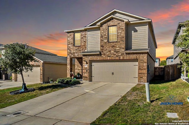 front facade with a garage and a lawn