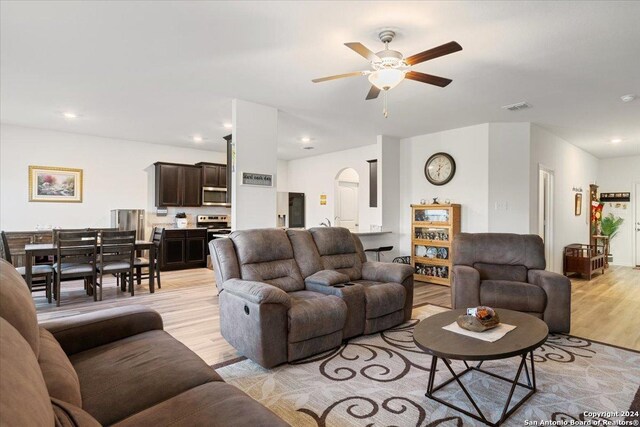 living room featuring light wood-type flooring and ceiling fan