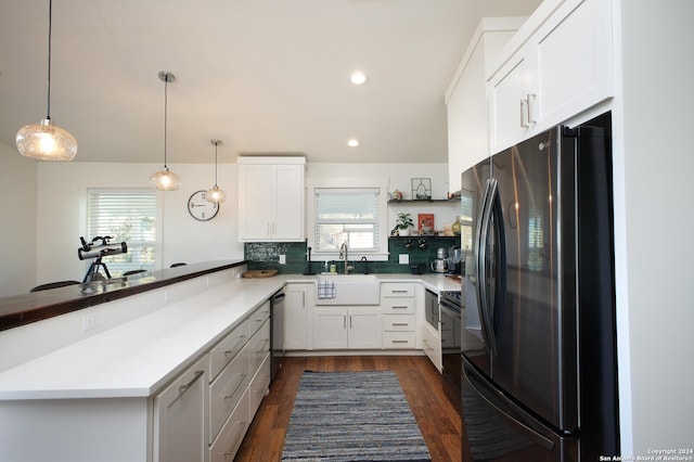 kitchen featuring kitchen peninsula, appliances with stainless steel finishes, white cabinets, and a wealth of natural light