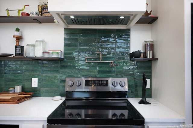 kitchen with stainless steel electric range, backsplash, and exhaust hood