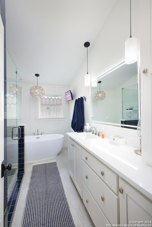 bathroom with separate shower and tub, vanity, lofted ceiling, and a notable chandelier