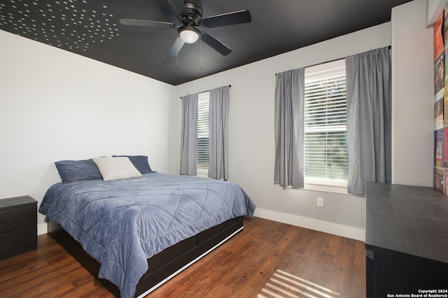 bedroom with ceiling fan and dark hardwood / wood-style floors