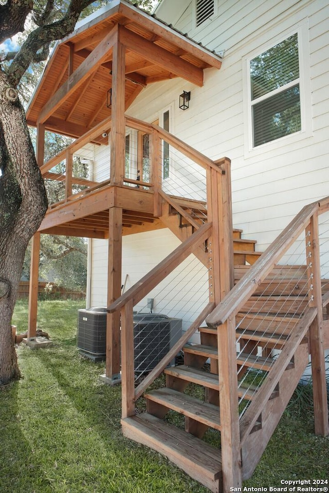 deck with central AC unit and a lawn