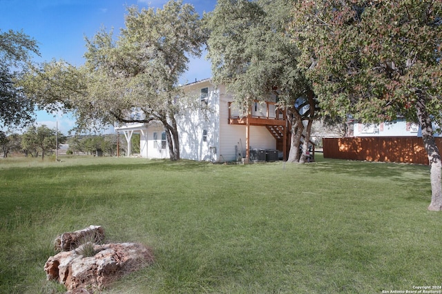 view of yard with central AC and a wooden deck