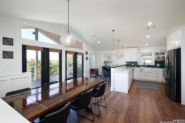 kitchen with white cabinetry, kitchen peninsula, stainless steel fridge, and pendant lighting