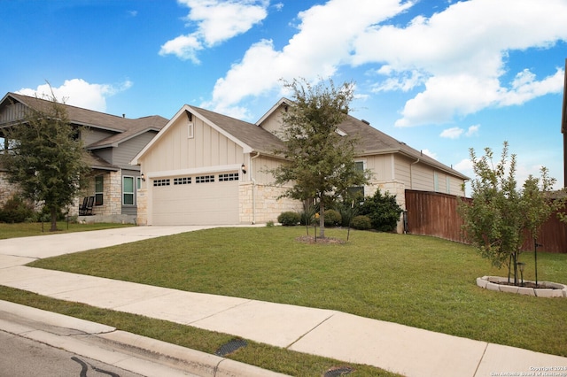 view of front of house featuring an attached garage, fence, driveway, a front lawn, and board and batten siding