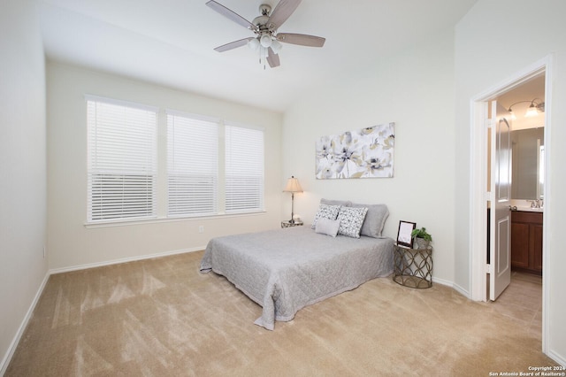 bedroom featuring connected bathroom, light colored carpet, ceiling fan, and sink