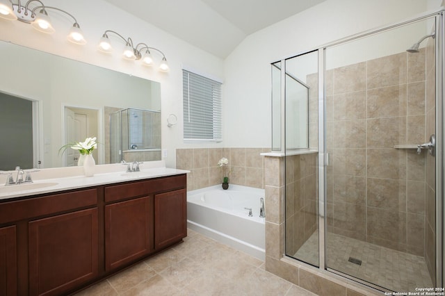 bathroom featuring tile patterned flooring, vanity, vaulted ceiling, and shower with separate bathtub