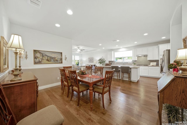 dining area with light wood-type flooring and ceiling fan