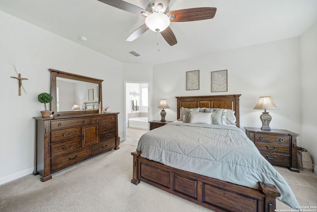 bedroom featuring ensuite bathroom, light carpet, and ceiling fan