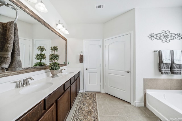 bathroom featuring vanity, tile patterned flooring, and a bathtub