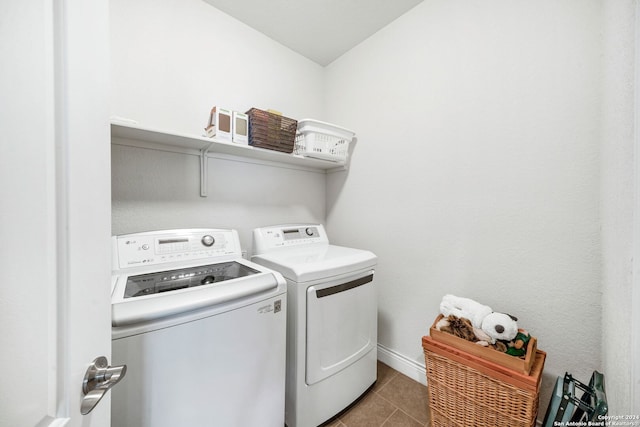 clothes washing area featuring dark tile patterned floors and washer and clothes dryer