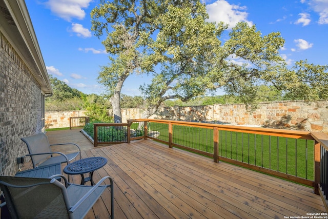 wooden deck featuring a lawn