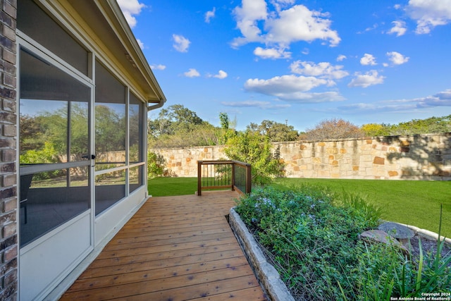 deck featuring a yard and a sunroom