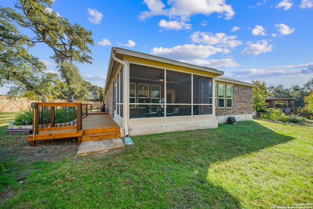 back of house with a yard, a sunroom, and a wooden deck