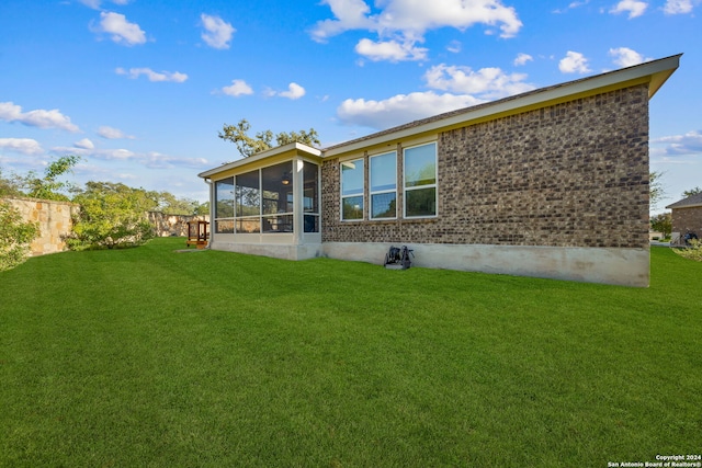 back of house with a lawn and a sunroom