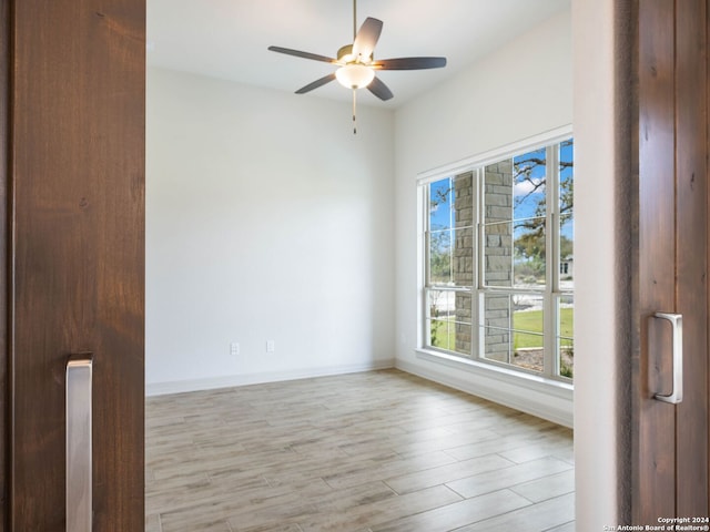 unfurnished room with light hardwood / wood-style flooring, plenty of natural light, and ceiling fan