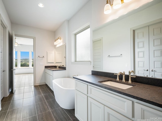 bathroom with vanity, ceiling fan, and a tub