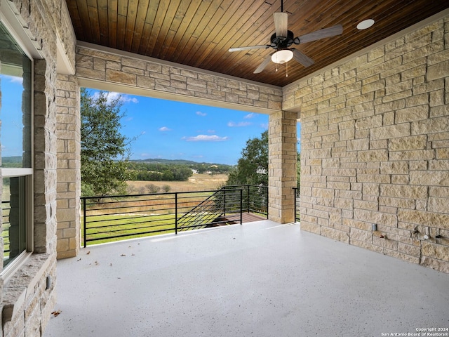 view of patio with ceiling fan and a balcony