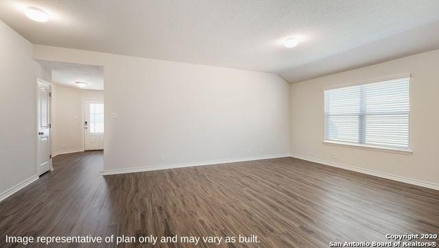 spare room featuring plenty of natural light, dark hardwood / wood-style flooring, lofted ceiling, and a textured ceiling