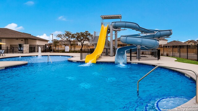 view of swimming pool featuring pool water feature, a patio area, and a water slide