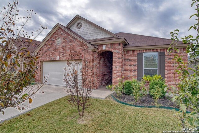 ranch-style home with a garage and a front lawn