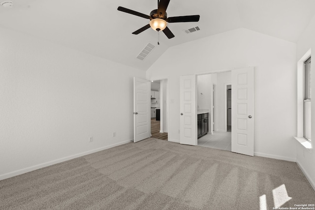 unfurnished bedroom featuring light carpet, lofted ceiling, visible vents, and baseboards