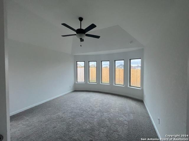 carpeted spare room featuring ceiling fan and baseboards