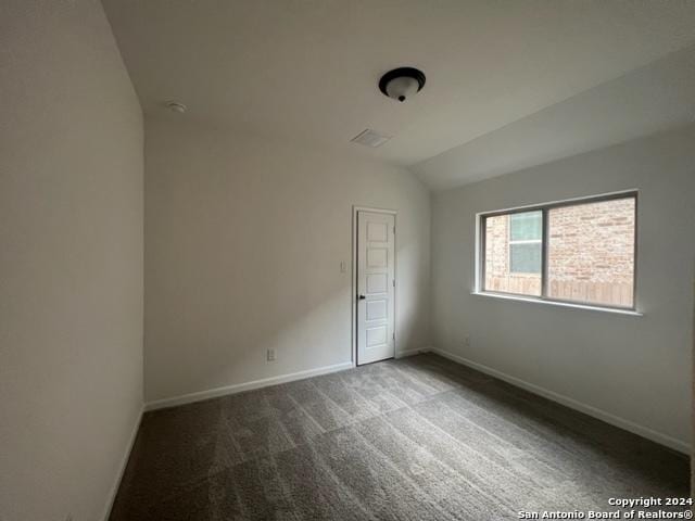 carpeted empty room with lofted ceiling and baseboards