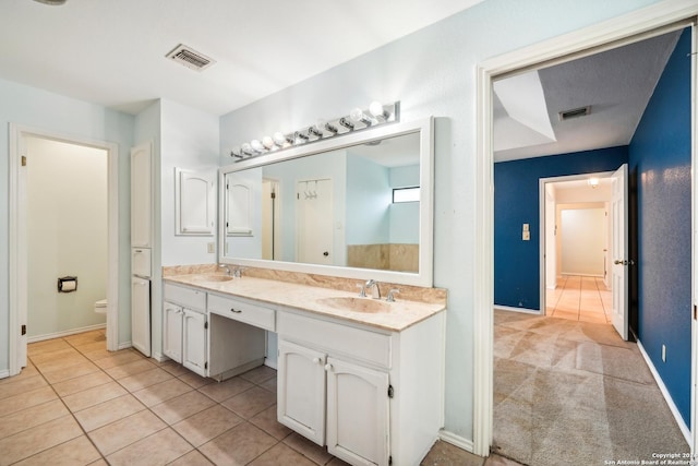 bathroom with tile patterned flooring, vanity, and toilet