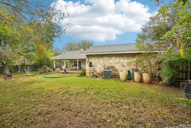 rear view of house with a lawn, central AC, and a patio