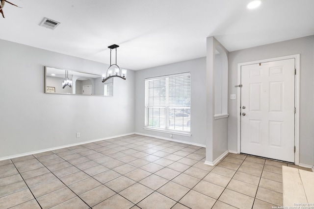 tiled entrance foyer featuring a chandelier