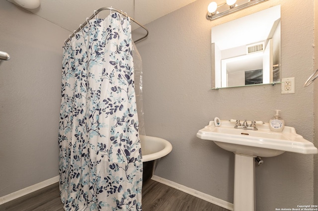 bathroom with hardwood / wood-style flooring and walk in shower