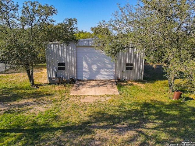 view of outdoor structure featuring a lawn and a garage