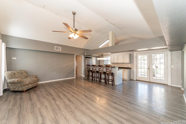 unfurnished living room featuring french doors, hardwood / wood-style flooring, and lofted ceiling