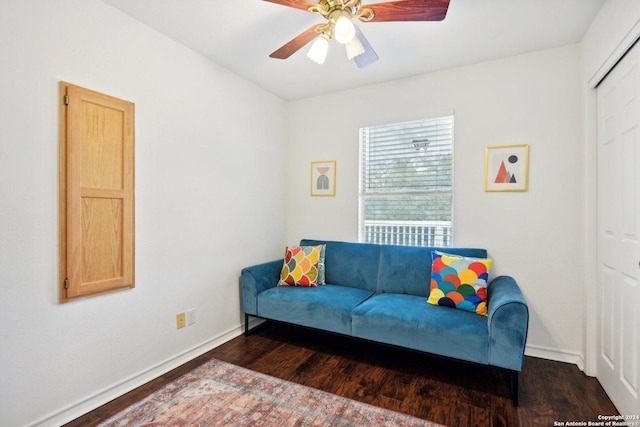 living room featuring ceiling fan and dark hardwood / wood-style flooring